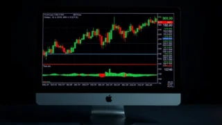 AI trading algorithms: computer monitor displaying trading chart data dark